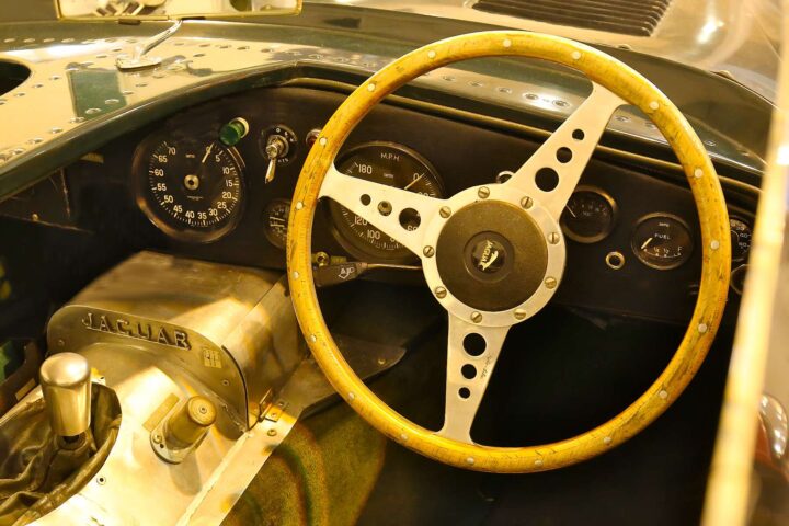 1956 Jaguar D-Type race car dashboard and cockpit with classic instruments and wooden steering wheel